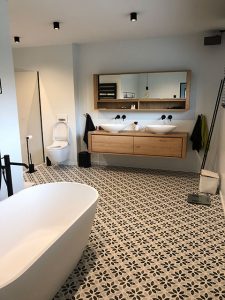 Badkamer met dubbele lavabo en vrijstaand bad in moderne Quackels villa