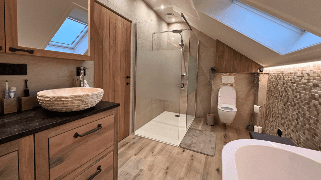 Badkamer met douche, dubbele lavabo, toilet en ligbad in een recente vakantiewoning