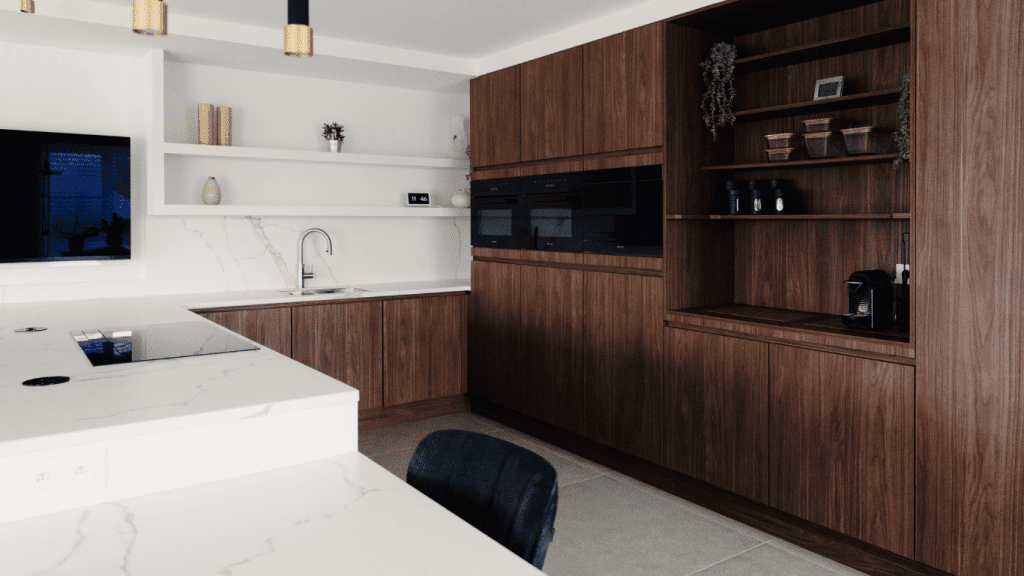 Donkere, moderne keuken in donker notenhout en witte, marmeren keukenblad.