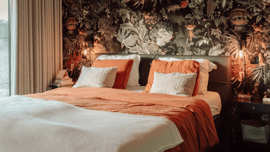Slaapkamer met kleurrijke oranje, groene muur en oranje dekbed in nieuwbouw in de Kempen.
